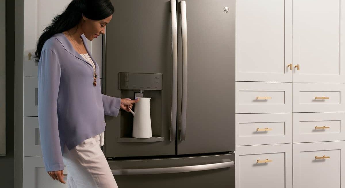 Woman serving water from fridge