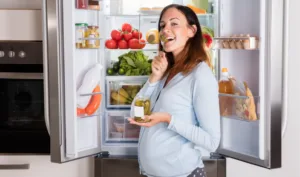 refrigerator repair pregnant woman checking fridge